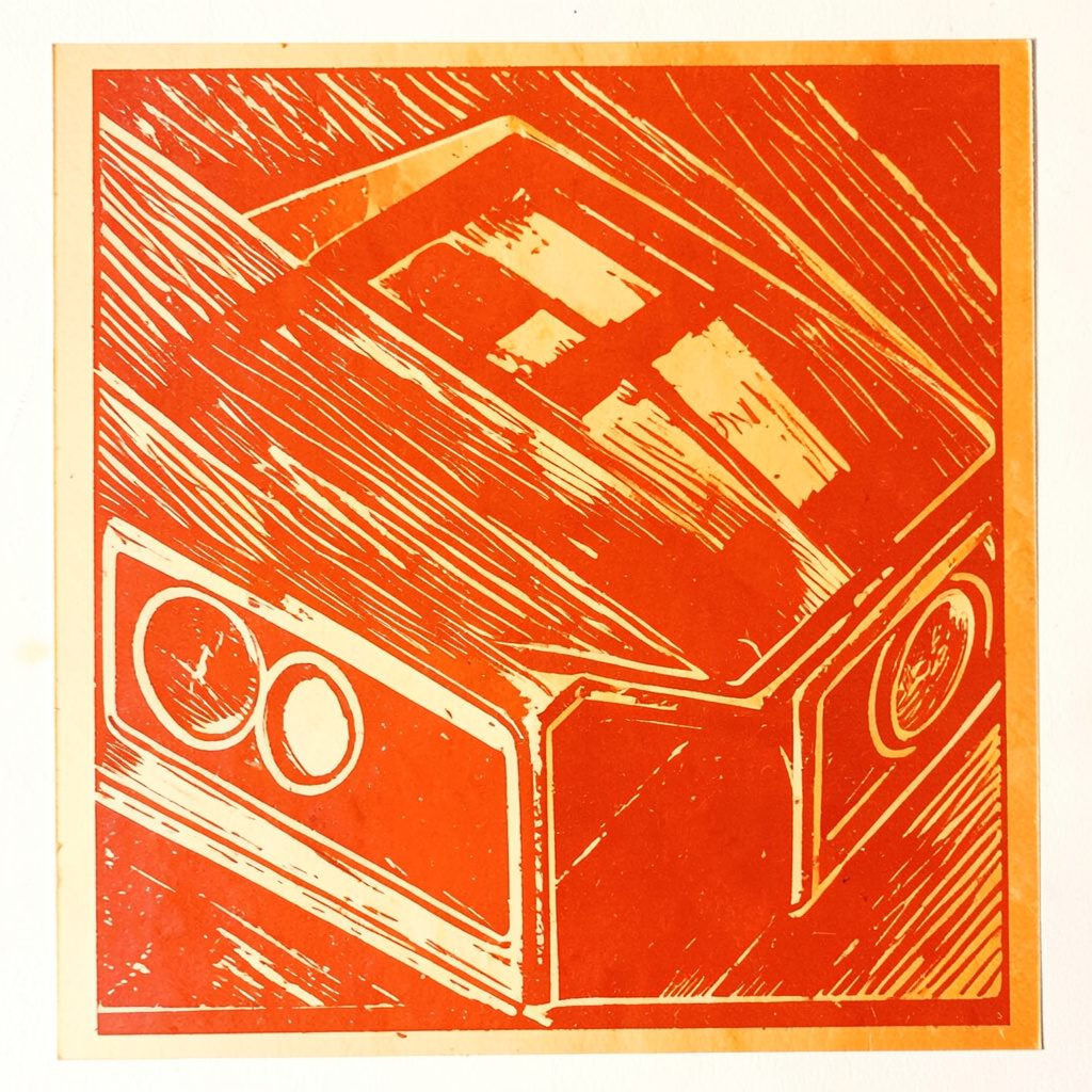 A linocut relief print in navy blue and cream, depicting a close-up of playing cards fanned across a green felt surface, with bold carved lines suggesting tension and concentration.